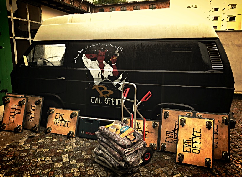 EVIL OFFICE Firmenwagen mit Teufelsmaskottchen und Transportmaterial im Berliner Innenhof – bereit für Ankauf und Büroauflösung